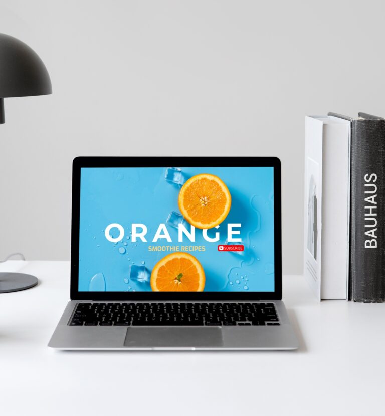 Mockup of Apple MacBook with Books and Lamps in White Desk